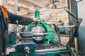 Turner worker manages the metalworking process of mechanical cutting on a lathe