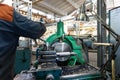 Turner worker manages the metalworking process of mechanical cutting on a lathe