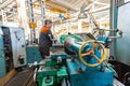 Turner worker manages the metalworking process of mechanical cutting on a lathe