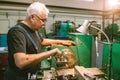 Turner worker senior old man is working on a lathe machine in a factory. Royalty Free Stock Photo