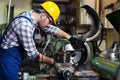 Turner worker is working on a lathe machine in a factory.