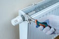 Turning down thermostat on radiator to save energy due to heating cost price hike. savings on heating. heating and energy costs