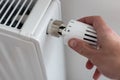 turning down thermostat on radiator to save energy due to heating cost price hike Royalty Free Stock Photo