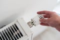 turning down thermostat on radiator to save energy due to heating cost price hike Royalty Free Stock Photo