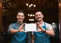 Turning the dream into reality. Portrait of two cheerful businessmen holding up a digital tablet together while standing Royalty Free Stock Photo