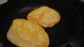 Turning by fork Homemade chapati flat pancake-like bread cooked on a griddle with oil