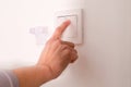 Turning off/on the wall-mounted electric light switch. Royalty Free Stock Photo