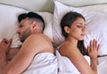 Turning their back to each other and their problems. a young married couple angry at each other in their bed at home. Royalty Free Stock Photo