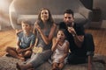 Turning their living room into a cinema. a young family relaxing on the floor and watching movies together at home. Royalty Free Stock Photo