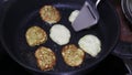 Turning zucchini pancakes when frying in a frying pan on oil, cooking