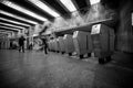 Turnstile in Kyiv underground with moving blurry people and bright station light.