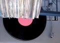 Turntable in gray case and row of many close standing vinyl records in old color covers on a desk top view Royalty Free Stock Photo