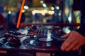 Turntable, hand of dj on the vinyl record at night club. blured background Royalty Free Stock Photo