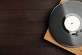 Turntable with vintage vinyl record on wooden background, top view. Space for text Royalty Free Stock Photo