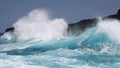 Turqoise waves crashing against lava cliffs