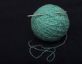 Turquoise ball of acrylic-wool yarn and crochet hook