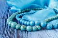 Turquoise beads on blue wooden background