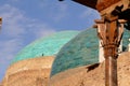 The turquoise blue domes of Khiva with the caption of a carved pillar