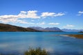Turquoise blue lake Tekapo surrounded by hills of Southern Alps in back