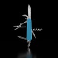 Turquoise blue Swiss Army Knife standing upright against a black background. 3D illustration