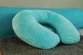 Turquoise orthopedic bright soft travel neck pillow on the bed