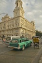 Turquoise 1955 Buick car and bicycle taxi driving the streets of Old Havana, Cuba