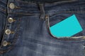 Turquoise business card in a pocket of blue jeans