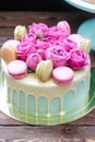 Turquoise cake with white melted chocolate, fresh roses and french macaroons decoration Royalty Free Stock Photo