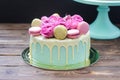 Turquoise cake with white melted chocolate, fresh roses and french macaroons decoration Royalty Free Stock Photo