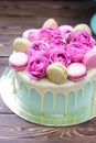 Turquoise cake with white melted chocolate, fresh roses and french macaroons decoration Royalty Free Stock Photo