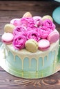 Turquoise cake with white melted chocolate, fresh roses and french macaroons decoration Royalty Free Stock Photo