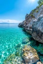 Turquoise clear water reflecting sunlight along rocky coast Royalty Free Stock Photo