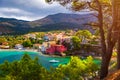 Turquoise colored bay in Mediterranean sea with beautiful colorful houses in Assos village in Kefalonia, Greece. Town of Assos