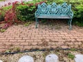 Turquoise colored bench in brick courtyard