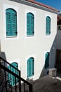 Turquoise colored window shutters on a white house. Wooden windows with closed shutters. Shutters on the windows protect Royalty Free Stock Photo