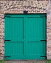 Turquoise doors surrounded by brick wall Royalty Free Stock Photo