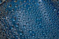 Turquoise drops flow down on the blue mirror ice surface. Close-up.