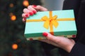 Turquoise gift box in the hands of a girl. Royalty Free Stock Photo