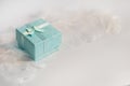 Turquoise gift box on white angel feather wings