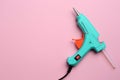 Turquoise glue gun with stick on background, top view. Space for text Royalty Free Stock Photo