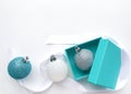 Turquoise jewelry box with a silver Christmas ball inside, on the left - Christmas glittery balls of white and blue, white ribbon