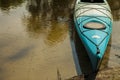 Turquoise kayak by the river