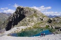 An turquoise lake in the Italian Alps with people hiking and climbing the mountain Italy