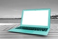 Turquoise Laptop computer on wooden table. Front ocean view. Tropical island background. Open blank laptop computer empty space. Royalty Free Stock Photo