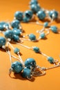Turquoise necklaces over orange background