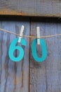 Turquoise number 60 pegged on a blue wooden door