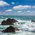 Turquoise ocean waves, rocks coastline and blue sky