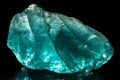 Turquoise piece of glass on a black background. Royalty Free Stock Photo