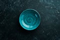Turquoise plate on a black stone background. Royalty Free Stock Photo