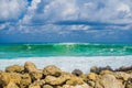 Turquoise rolling wave slamming on the rocks of the coastline